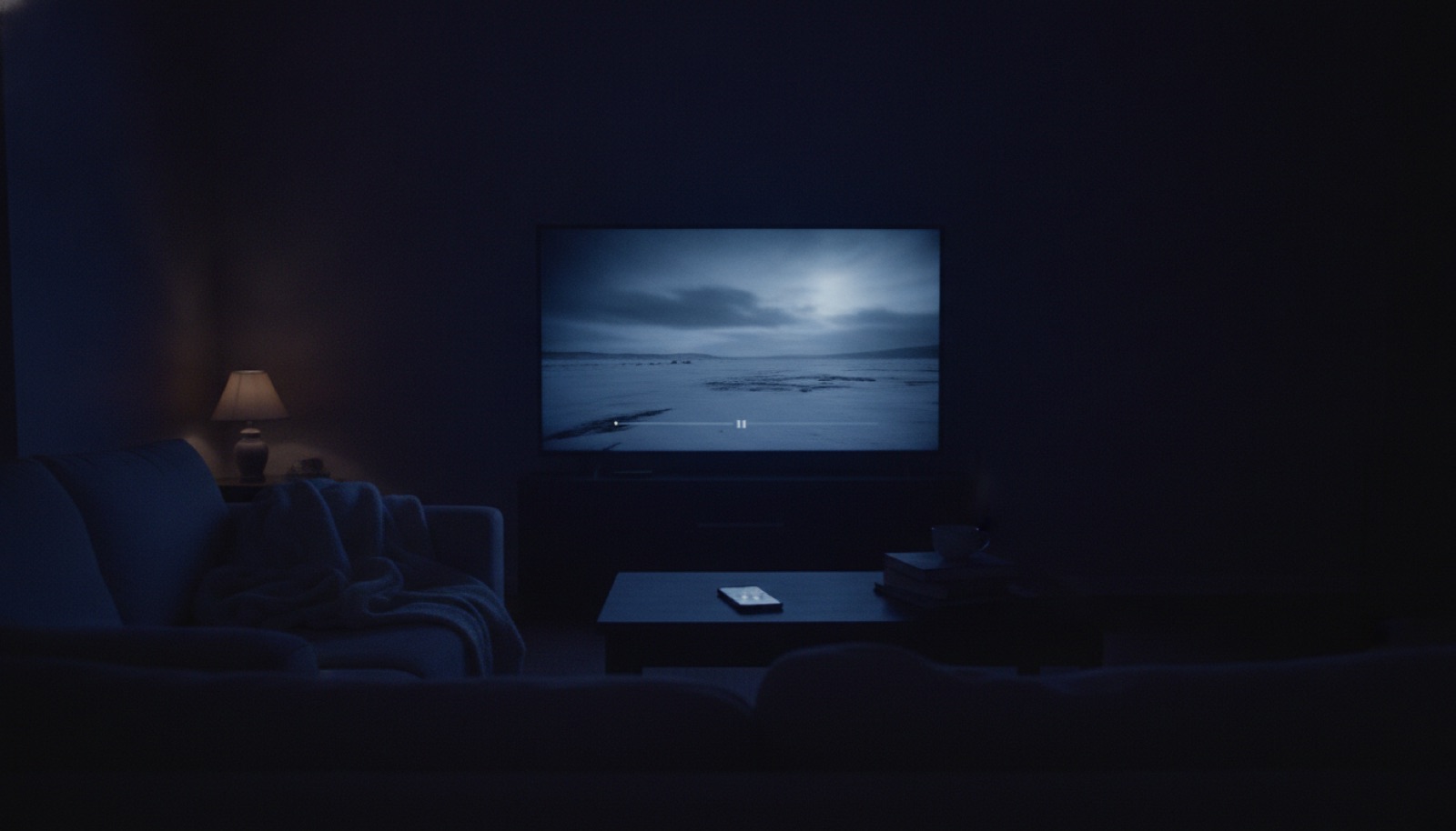 A living room at night with a movie paused on the television